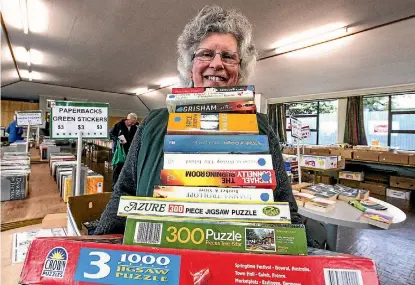  ?? PHOTO: DOUG FIELD/STUFF ?? Cecilia Davis, of the Red Cross, Timaru, sorts items at the charity’s annual book sale on Monday.