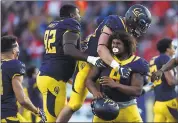  ?? JOSE CARLOS FAJARDO — STAFF ARCHIVES ?? James Looney, right, is mobbed by his teammates after making a last-second defensive stop to preserve a win over Utah. The senior defensive lineman is expected to be a key part of the Bears’ new 3-4defensive alignment.