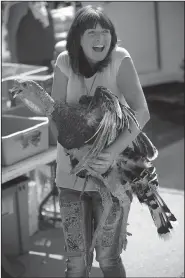  ?? NWA Democrat-Gazette/ANDY SHUPE ?? Lisa Chism of Gassville laughs Saturday after catching one of several wild turkeys released from atop the Marion County Courthouse during the annual Turkey Trot in Yellville.