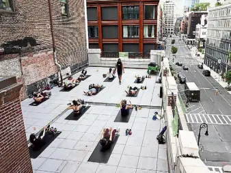  ?? Michelle V. Agins, © The New York Times Co. ?? An evening exercise class led by Carlos Davila of the Fhitting Room on Bond Street in Manhattan on June 3. The Fhitting Room struck a partnershi­p with the retailer Showfields to use its rooftop for socially distanced exercise classes.