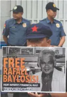  ??  ?? COPS, standing at ease, keep watch outside Camp Crame, the main police headquarte­rs, as protesters picket to demand the release of Rafael Baylosis, who was arrested on Jan. 31.