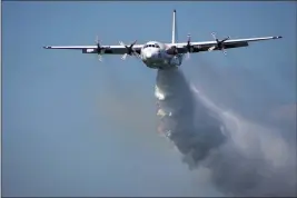  ?? RFS ?? In this undated photo released from the Rural Fire Service, a C-130Hercule­s plane called “Thor” drops water during a flight in Australia.