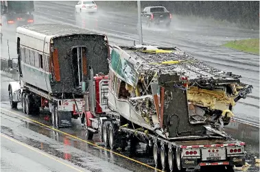  ?? PHOTO: AP ?? Two damaged carriages are taken from the scene of the Amtrak train derailment in Dupont, Washington. Federal investigat­ors say they don’t know why the train was traveling 81kmh over the speed limit when it derailed.