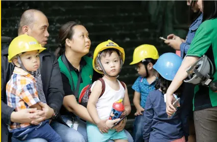  ?? AP FOTO ?? QUAKE: Children wear helmets as they evacuate a building after an earthquake was felt in Manila Friday.