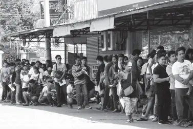  ?? BING GONZALES ?? RESIDENTS queue to have their driver’s license renew at the Driver’s License Renewal Office of the Land Transporta­tion Office’s in Toril on Friday, the last day of office this year.