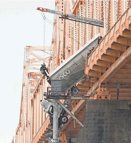  ?? ?? Rescuers work to get a driver out of the cab of a tractor trailer on the Clark Memorial (Second Street) Bridge on Friday.