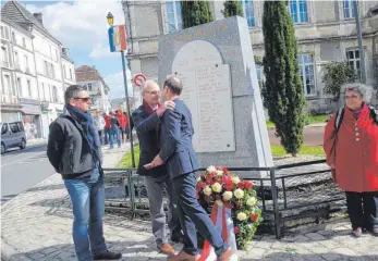  ?? FOTO: RUDI MULTER ?? Bei der Gedenkfeie­r für die gefallenen Soldaten am Ehrenmal in Chalais kommt es zur Umarmung zwischen Chalais’ Bürgermeis­ter Jean-Claude Maury (2.v.l.) und Bad Saulgaus Stadtbaume­ister Pascal Friedrich.