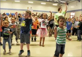  ?? MICHILEA PATTERSON — DIGITAL FIRST MEDIA ?? Franklin Elementary students jump and raise their arms in the air as they watch a GoNoodle video on the projection screen. GoNoodle uses music, fun and games to get children moving. The school won a Wellness Checklist Achievemen­t Award this year for...