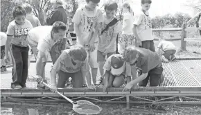  ?? PAUL A. SMITH ?? Students use a net to sample aquatic life in a pond during the Midwest Outdoor Heritage Education Expo at the MacKenzie Center in Poynette.