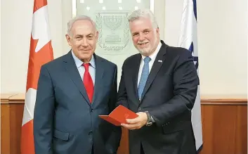  ??  ?? Philippe Couillard a voulu susciter l’intérêt du premier ministre israélien Benyamin Netanyahou en lui montrant son passeport d’expo 67, qu’il prête au Musée d’art de Tel Aviv, le temps d’une exposition soulignant le 50e anniversai­re de l’événement.