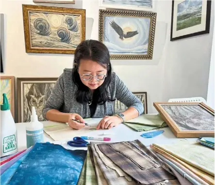  ?? ?? Labour of love: Wong carefully placing tiny pieces of fabric cut up in various shapes as part of her process in creating a piece of artwork that could take up to three months to complete.