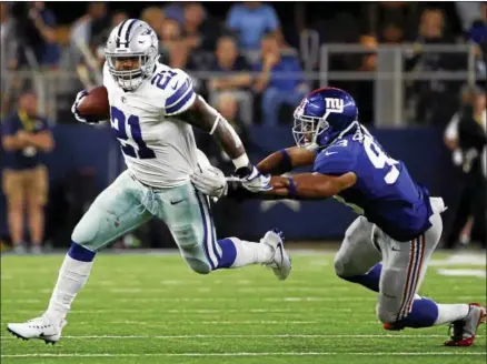  ?? RON JENKINS - THE ASSOCIATED PRESS ?? Dallas Cowboys running back Ezekiel Elliott (21) escapes a tackle attempt by New York Giants linebacker B.J. Goodson (93) in the second half of an NFL football game, Sunday, Sept. 10, 2017, in Arlington, Texas.