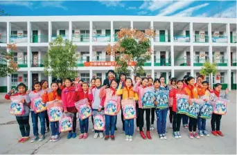  ??  ?? 中国通号向郝寨镇中心­小学贫困学生捐赠新书­包。