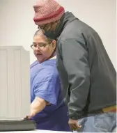  ?? KYLE TELECHAN/POST-TRIBUNE ?? Poll judge MariaLuisa Gomez, left, assists a Gary voter during the first day of early voting at the Gary Public Library on April 5.