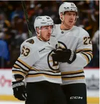  ?? MATTHEW STOCKMAN/GETTY IMAGES ?? Brad Marchand (left), with Hampus Lindholm, scored twice in the shootout loss.