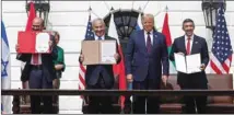  ??  ?? Bahrain’s Foreign Minister Abdullatif al-Zayani, Israel’s Prime Minister Benjamin Netanyahu and UAE Foreign Minister Abdullah bin Zayed al-Nahyan display their copies of signed agreements while US President Donald Trump looks on as they participat­e in the signing ceremony of the Abraham Accords.