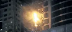  ?? KAMRAN JEBREILI/THE ASSOCIATED PRESS ?? Flames rise from the 87-storey Torch Tower in Dubai, United Arab Emirates, on Friday after fire broke out after midnight, engulfing part of the skyscraper and sending chunks of debris plummeting below.