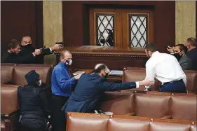  ?? SCOTT APPLEWHITE/ AP ?? U.S. Capitol Police with guns drawn watch as protesters try to break into the House Chamber.