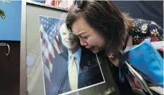  ?? NHAC NGUYEN / AFP / GETTY IMAGES ?? Mai Tran, an American of Vietnamese descent, grieves over a portrait of John McCain during a memorial tribute at the US Embassy in Hanoi on Monday.