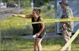  ?? CHARLES REX ARBOGAST/AP ?? Two pedestrian­s look into downtown Highland Park, Illinois, Tuesday behind police tape one day after a mass shooting in the northern Chicago suburb.