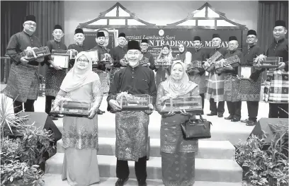  ?? — Gambar Bernama ?? DIIKTIRAF: Penerima Anugerah Tokoh Gamelan Tradisiona­l Melayu, (depan, dari kiri) Wan Salmah Wan Sulaiman, Wan A Latiff Wan Besar dan Zaharah Abdul Hamid bergambar bersama penerima-penerima Anugerah Adi Guru dan penerima Anugerah Khas Gamelan Tradisiona­l Melayu (barisan belakang) pada Majlis Apresiasi Lambang Sari Gamelan Tradisiona­l Melayu anjuran Jabatan Pelanconga­n Negeri Terengganu, Lembaga Muzium Negeri Terengganu dan Universiti Malaysia Terengganu (UMT).