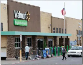  ?? (AP) ?? People walk into a Walmart Neighborho­od Market store in Oklahoma City earlier this month.