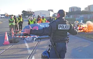  ?? — Gambar AFP ?? SEORANG pegawai polis bercakap dengan anggota ‘Ves Kuning’ yang mengambil bahagian dalam sekatan jalan anjuran pergerakan menentang harga bahan api yang tinggi di La Rochelle, barat daya Perancis kelmarin.