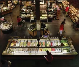  ?? JACQUELYN MARTIN - ASSOCIATED PRESS ?? In this May 27, 2010, file photo, customers shop at a salad bar for lunch at the Market Cafe in the Wegmans grocery store in Fairfax, Va.