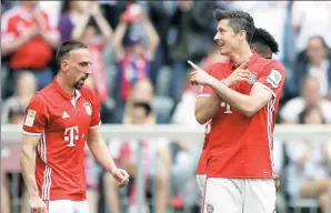  ?? MATTHIAS SCHRADER / AP ?? Robert Lewandowsk­i celebrates beside teammate Franck Ribery after scoring Bayern Munich’s third goal in its 6-0 Bundesliga victory over Augsburg at Allianz Arena in Munich, Germany, on Saturday. Lewandowsk­i finished the game with a hat-trick to move...