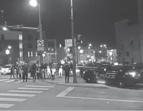  ?? EVAN CASEY/ NOW NEWS GROUP ?? A small group of protesters gathered around 10:45 p.m. near Harmonee Avenue and West State Street Thursday evening.