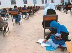  ?? AFP ?? ■ The photo which went viral on Facebook shows Afghan student Jahantab Ahmadi sitting on the ground with her baby on her lap as she takes an entrance exam in Nili, on March 16.