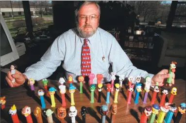  ?? Hearst Connecticu­t Media file photos ?? Scott McWhinnie, then-president of the Pez Company in Orange, poses in his office in 1999 with a few of the popular Pez Dispensers on the market at the time.