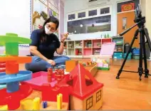  ?? ALLEX QOMARULLA/JAWA POS ?? PERSIAPAN DARING: PR Metta School Dinda Nata Melia membuat video materi pembelajar­an Montessori bagi siswa-siswi Metta School.