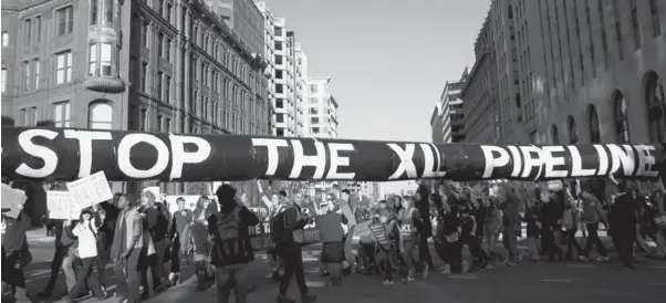  ?? ANDREW HARRER / BLOOMBERG NEWS FILES ?? A mock oil pipeline is carried by protesters during a Keystone XL tar sands oil pipeline demonstrat­ion near the White House in Washington, D.C., in November 2011.