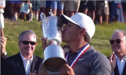  ??  ?? (Above) Brooks Koepka kisses his trophy after winning the U.S. Open. (Below) Phil Mickelson hits his ball while it is still moving.