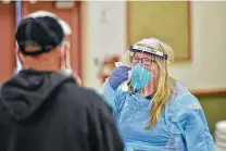  ?? Robin Jerstad / Contributo­r ?? Lynn Jusko instructs a patient during a free COVID-19 testing and food giveaway at St. Margaret Mary Catholic Church in San Antonio.