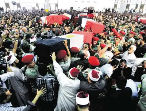  ??  ?? Military honours Egyptian soldiers carry coffins of their comrades, who were killed on Sunday during an attack at a checkpoint along the Sinai border with Israel by militants in Cairo yesterday. The coffins, wrapped in Egypt’s red-white-and-black flag,...