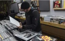  ??  ?? A customer picks through the stacks of records at Square Cat Vinyl in the Fountain Square neighbourh­ood.