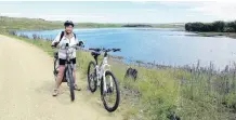  ?? PHOTO: GAVIN DANN ?? Return of the lake . . . Cathy Dann, of Alexandra, stops on the Otago Central Rail Trail to admire the newly formed Lake Taieri following floods at the start of the month.