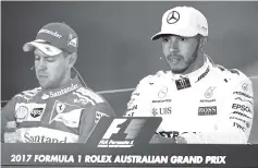  ??  ?? Mercedes’ British driver Lewis Hamilton (R) and Ferrari’s German driver Sebastian Vettel (L) face the media after the qualifying session at the Formula One Australian Grand Prix in Melbourne. - AFP photo