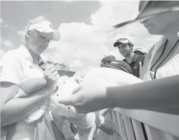  ?? GEOFF ROBINS/THE CANADIAN PRESS ?? Fifteen-year-old Brooke Henderson, of Smiths Falls, signs autographs following her final round 67 in the $1.3-million Manulife Financial LPGA Classic in Waterloo, Ont., on Sunday. She finished the tournament at 10-under-par.