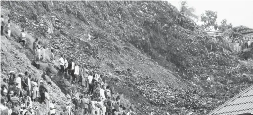  ?? — Gambar Reuters ?? TERTIMBUS: Orang ramai mengerumun­i tempat kejadian di tapak pelupusan sampah di kawasan kejiranan Dar Es Salam di pinggir Conakry, kelmarin.