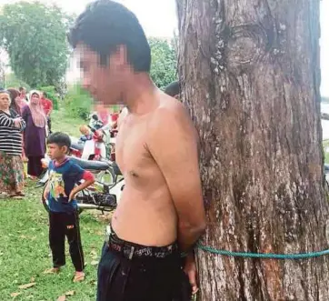  ??  ?? SUSPEK diikat pada pokok selepas ditangkap penduduk di Kampung Jubakar Pantai.