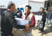  ?? MER-C ?? A volunteer from the Indonesian NGO Medical Emergency Rescue Committee hands over a food package to a Palestinia­n in Gaza.