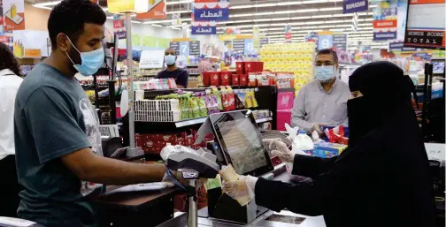 ?? ?? ±
A customer pays in cash counter at a hypermarke­t in Riyadh, Saudi Arabia.