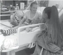  ?? MANCHESTER EVENING NEWS VIA AP ?? Grande visits Manchester concert attack victims Jaden Farrell-Mann, left, and Evie Mills at Royal Manchester Children’s Hospital.