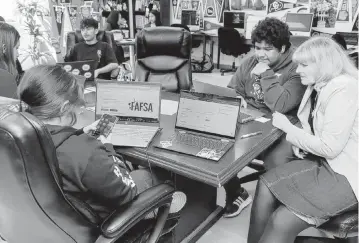  ?? IRFAN KHAN Los Angeles Times/TNS ?? Lynda McGee, right, a college counselor, helps students fill out the FAFSA at Downtown Magnets High School in Los Angeles. Filling out the FAFSA is how potential college students prove their financial eligibilit­y for aid for tuition.