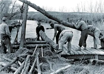  ??  ?? CRUZAR EL RÍO. En la encarnizad­a batalla, fue una constante la voladura y reconstruc­ción de puentes sobre el Jarama. Arriba, pontoneros de la 21ª Brigada Mixta, al mando del comandante Gómez Palacios, terminando de tender uno.