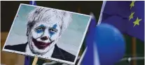  ?? MATT DUNHAM/ASSOCIATED PRESS ?? Protesters hold a sign showing Prime Minister Boris Johnson portrayed as the Joker as they take part in a march Saturday in London.