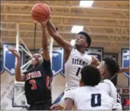  ?? ERIC BONZAR — THE MORNING JOURNAL ?? Elyria’s Michael Oliver (3) has his shot blocked by Lorain forward Octavious Wilson (1). Lorain is No. 1 in the Top of the Crop and Elyria is No. 2